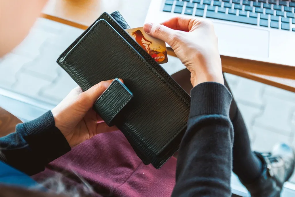A shopper paying online with a card while using a laptop